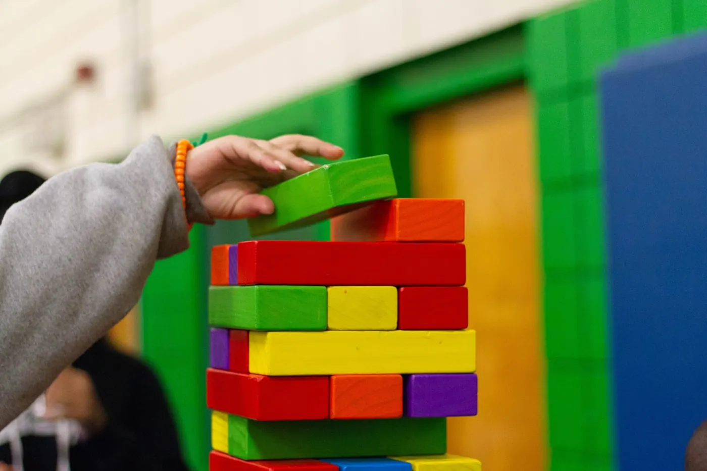 A therapist and child working with materials at a shared table.