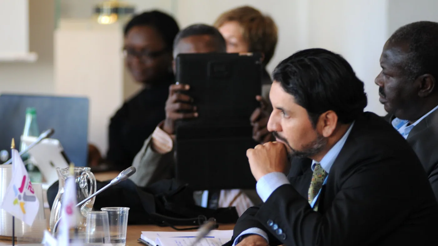 Practitioners in discussion around a conference table.