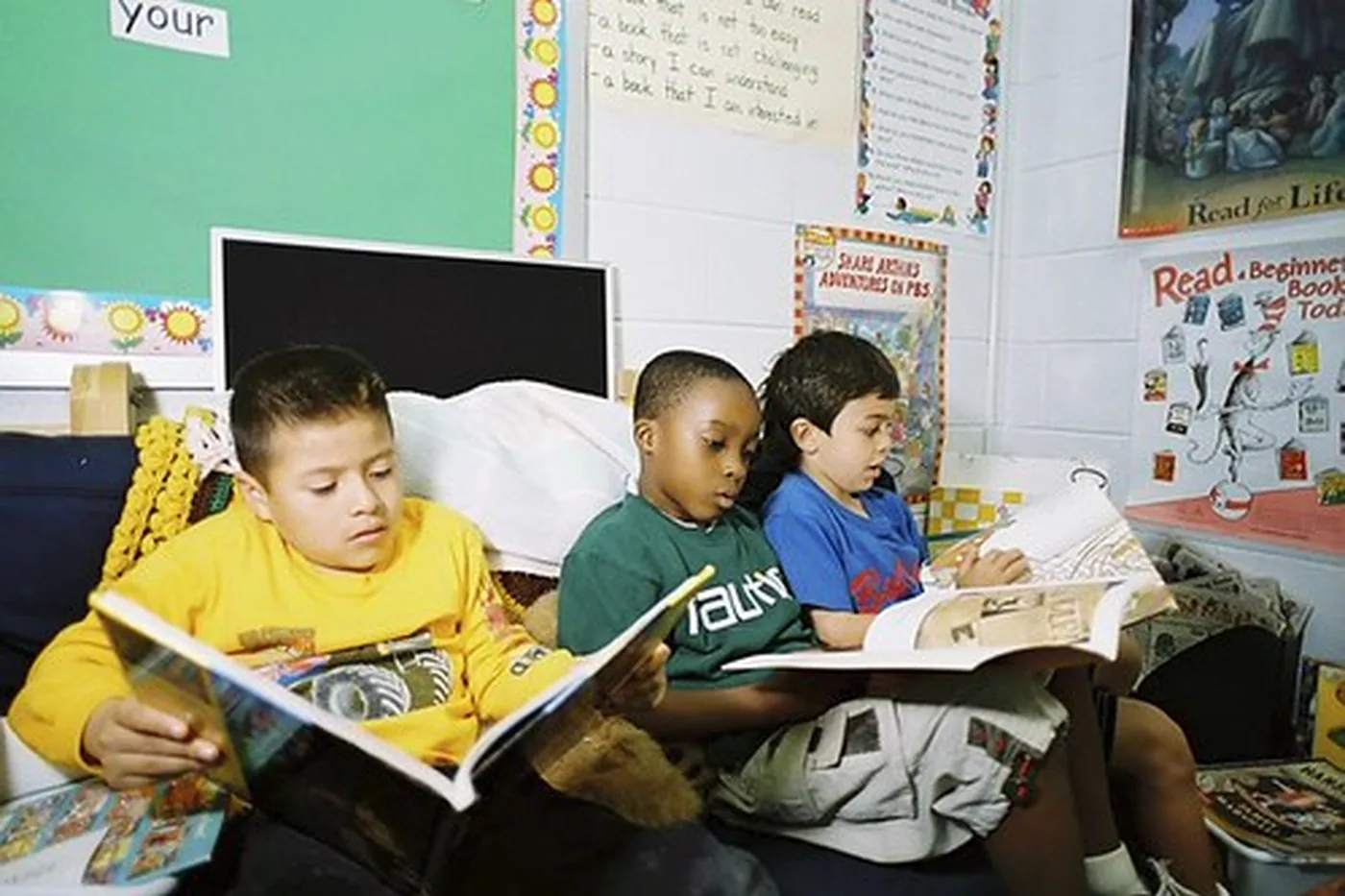 Children sitting together, reading.