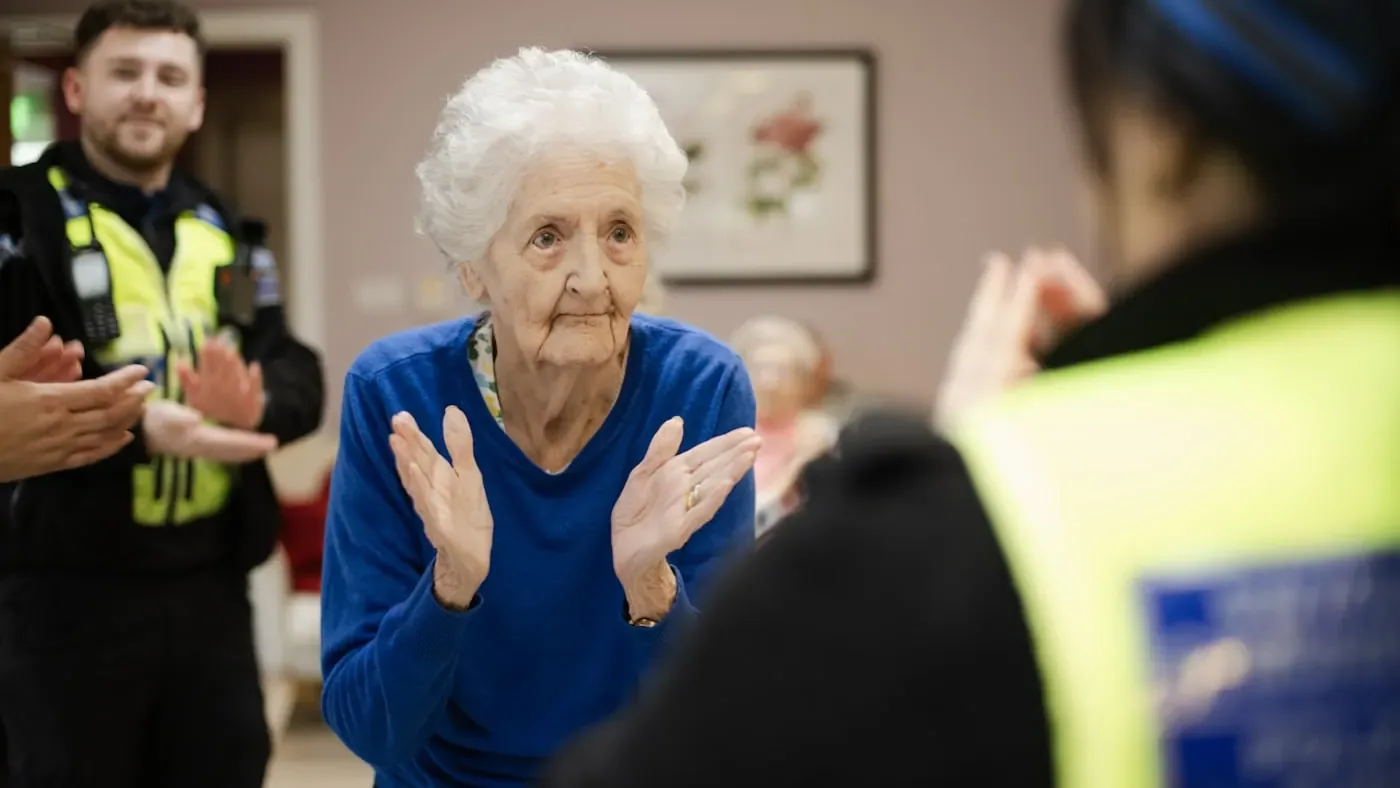 A volunteer with an older woman at a community event.