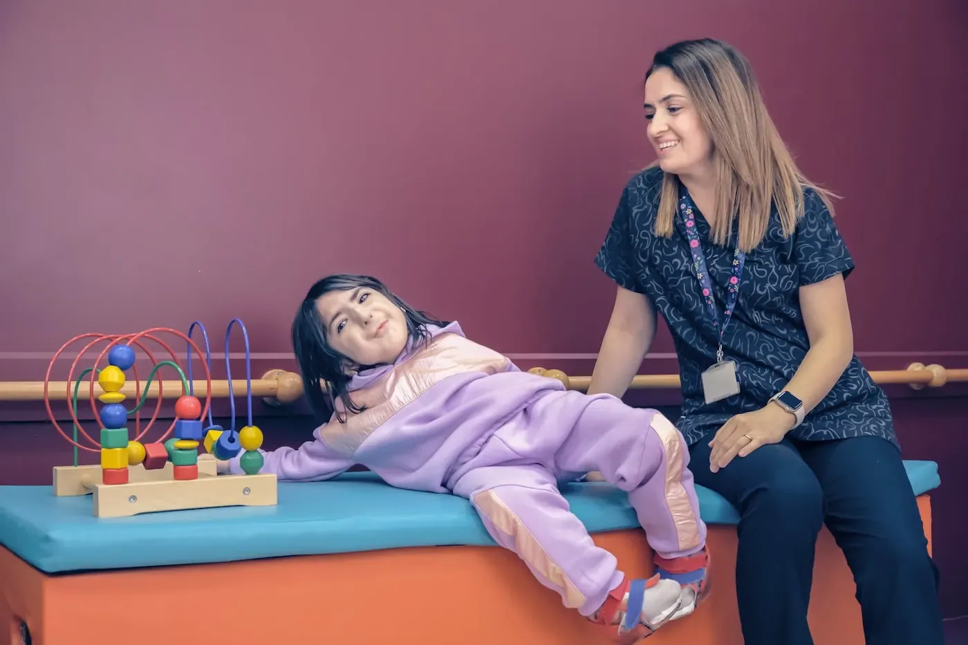 A therapist working with a child on a therapy mat.